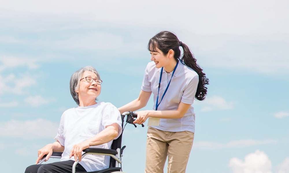 ご利用者様と職員が笑顔で散歩している光景